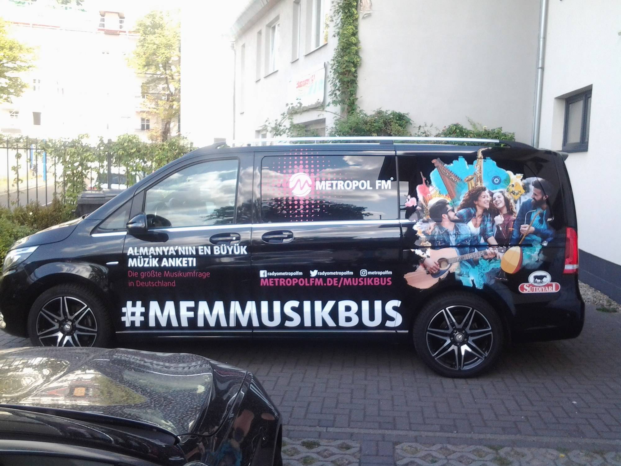 Schwarzer Van mit Vollfolierung „#MFMMUSIKBUS“ von Metropol FM